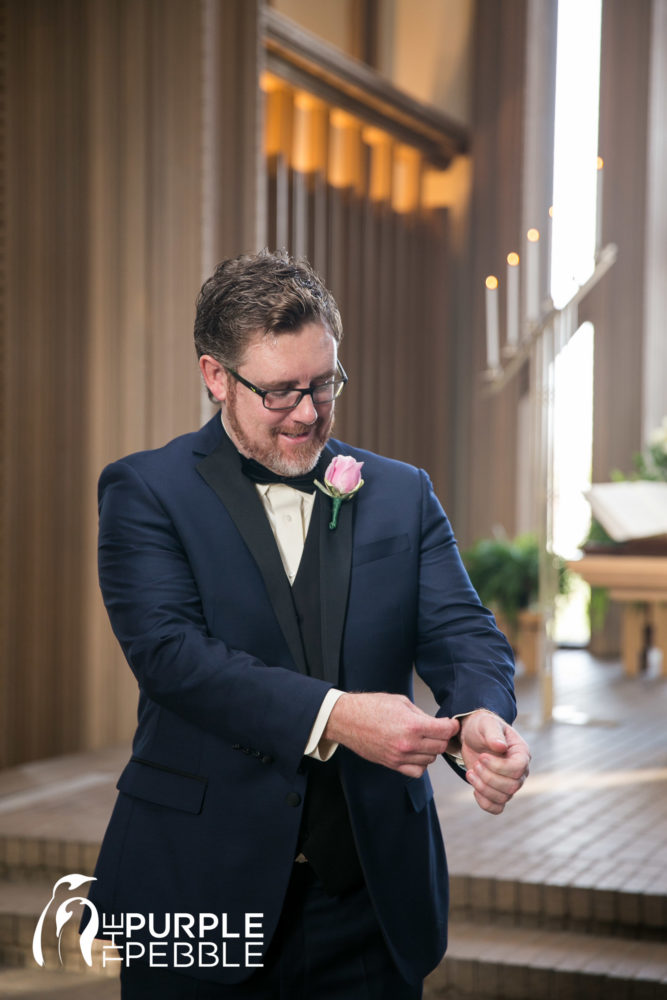 Groom getting into his suit on his wedding day